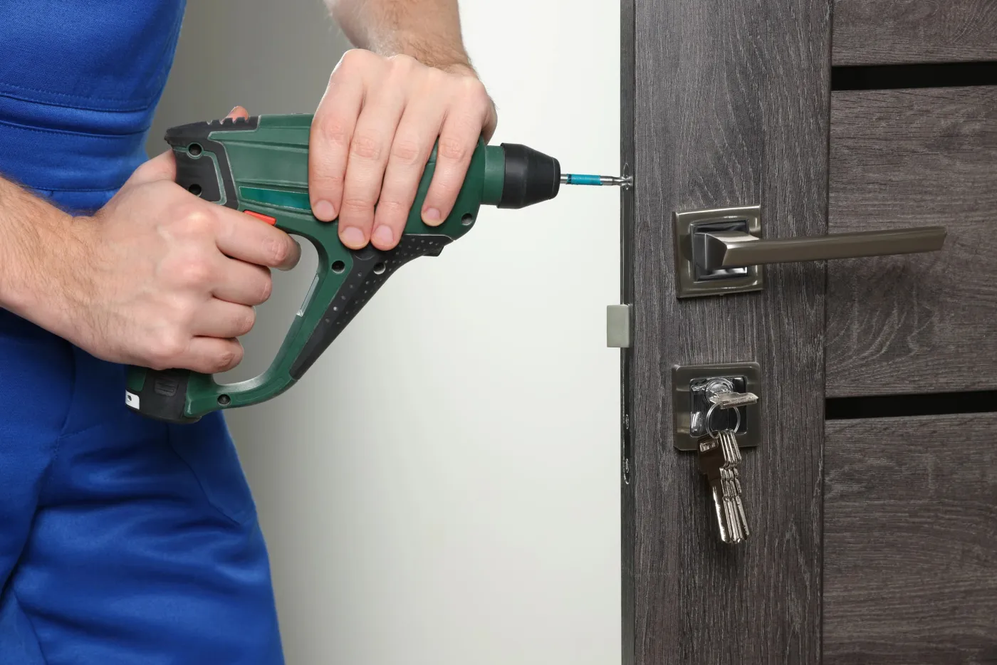 Serrurier installant une serrure de porte d'immeuble à Pantin